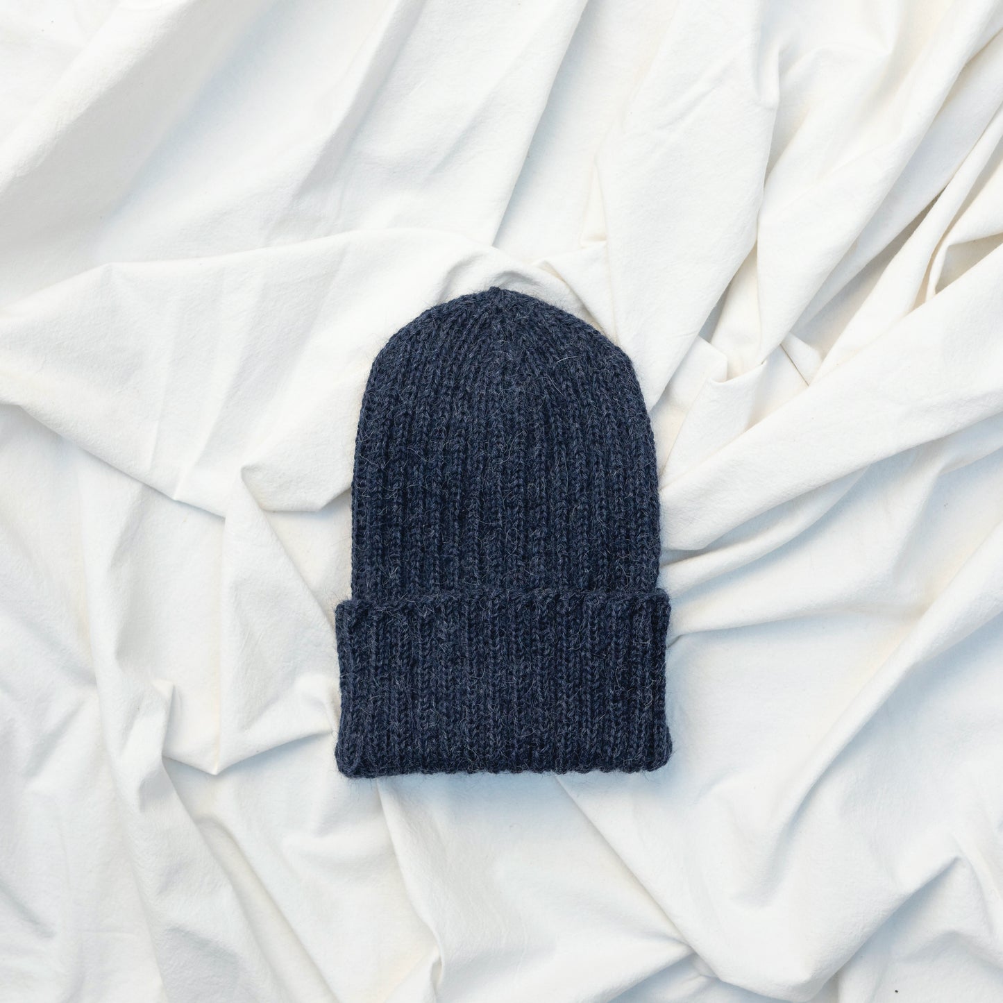 Dark blue coloured soft beanie with rib detail hand knitted with alpaca wool