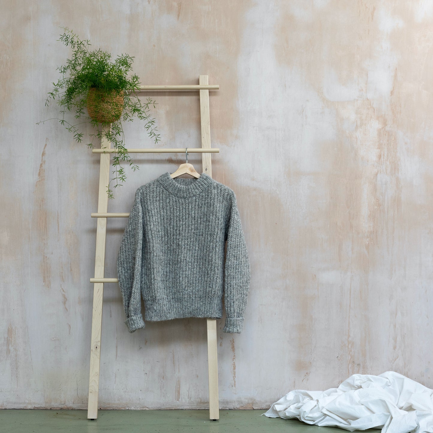Round neck chunky sweater, light grey, displayed on a ladder