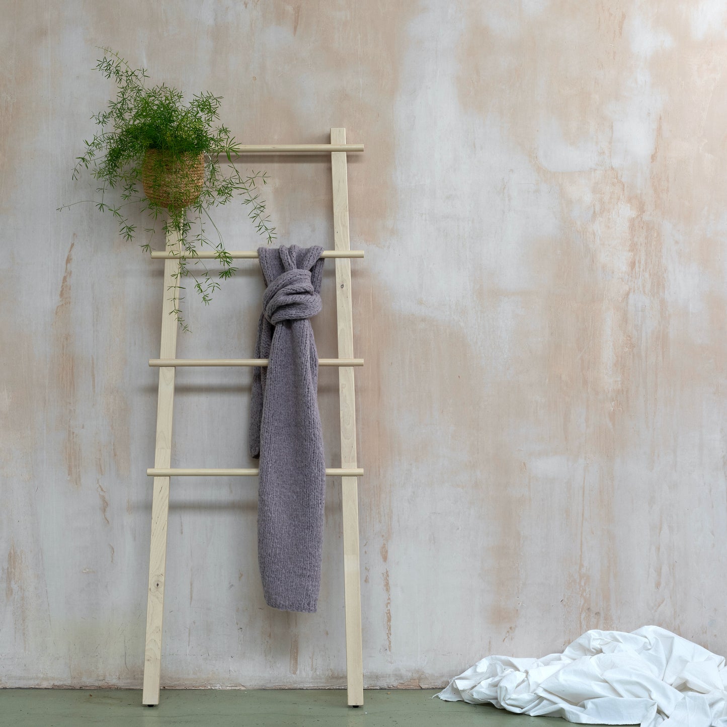 Lilac coloured supersoft alpaca scarf in chunky knit hanging from wooden stops