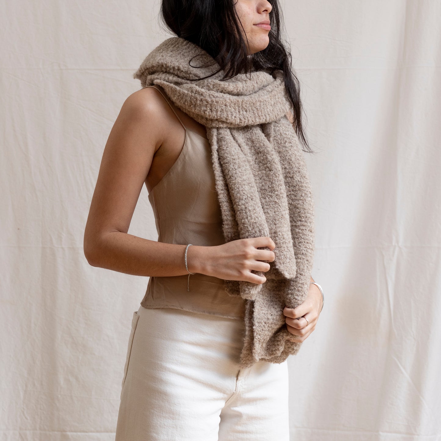 Woman with hand-knitted, cosy and artisan luxury alpaca wool chunky beige scarf