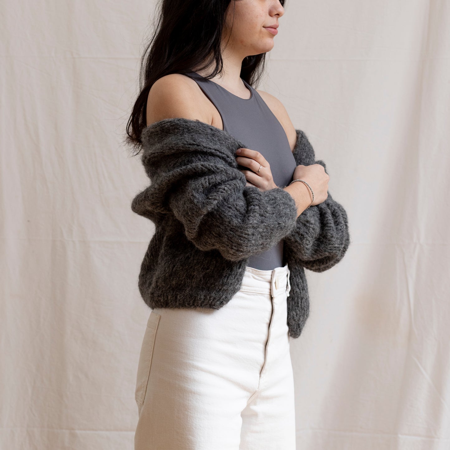Woman wearing charcoal coloured knitted alpaca wool cardigan. Super-soft and cosy.