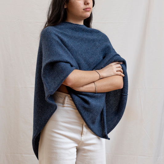 Woman wearing dark blue alpaca wool lightweight poncho.