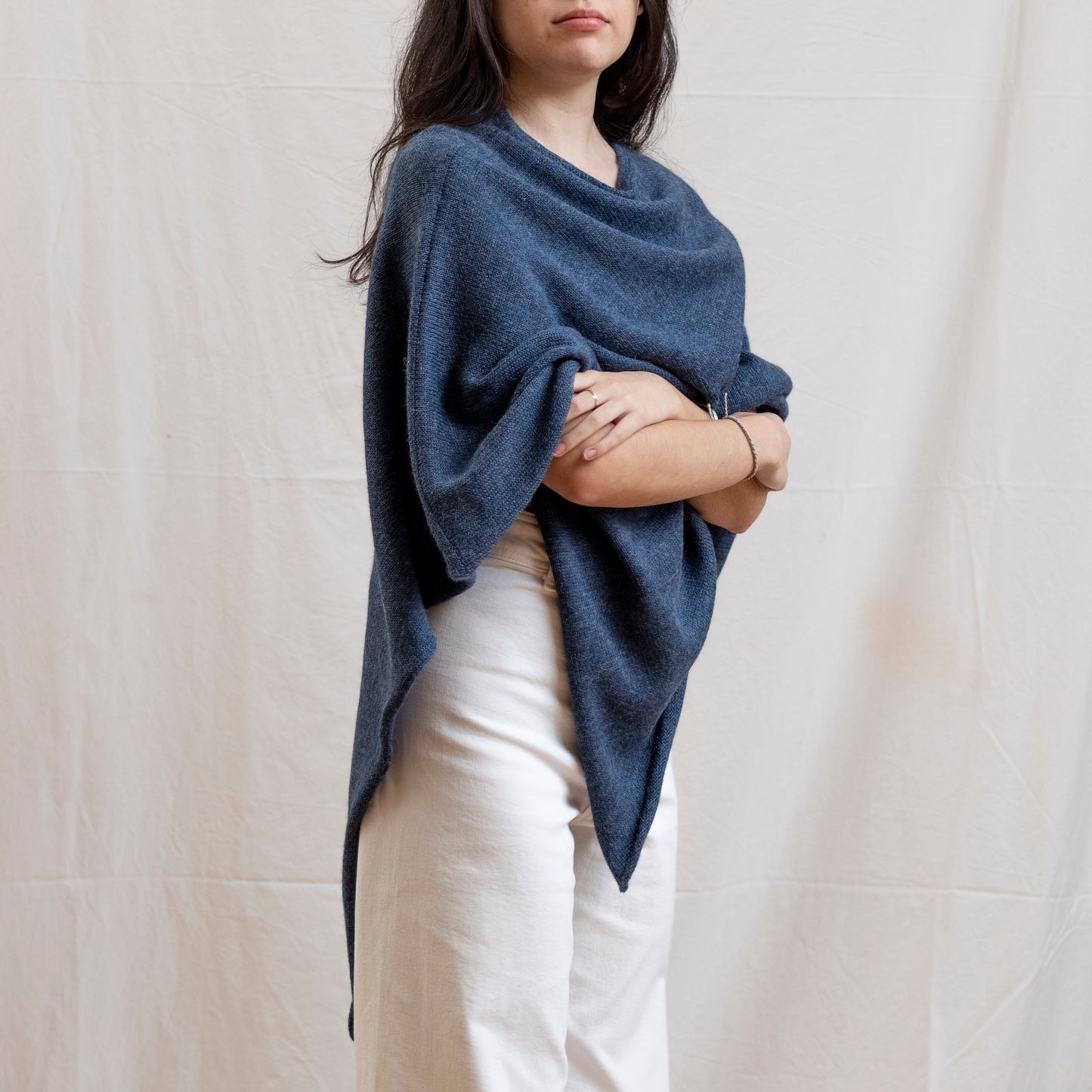 Woman wearing dark blue alpaca wool lightweight poncho.