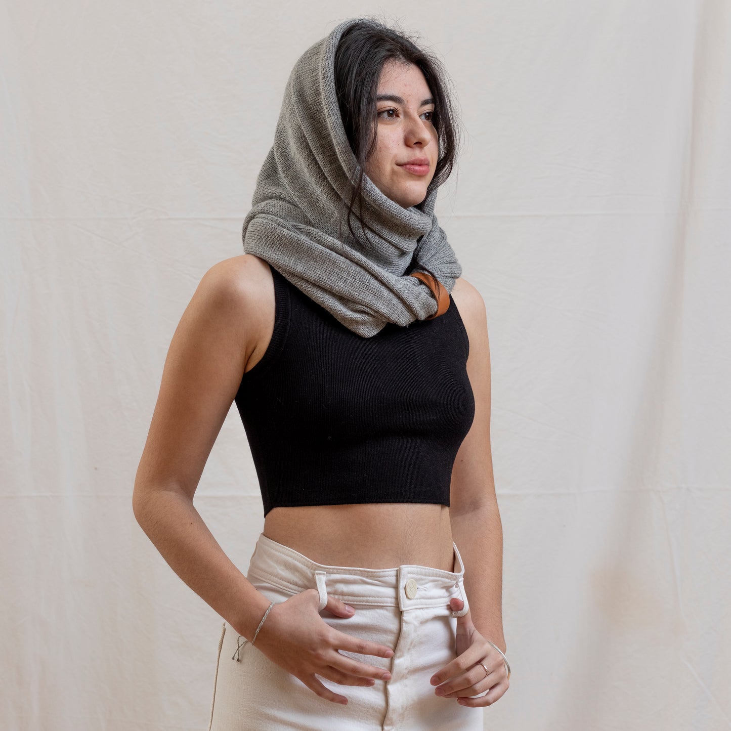 Woman wearing stone coloured luxury infinity scarf as a snood with leather strap detail.