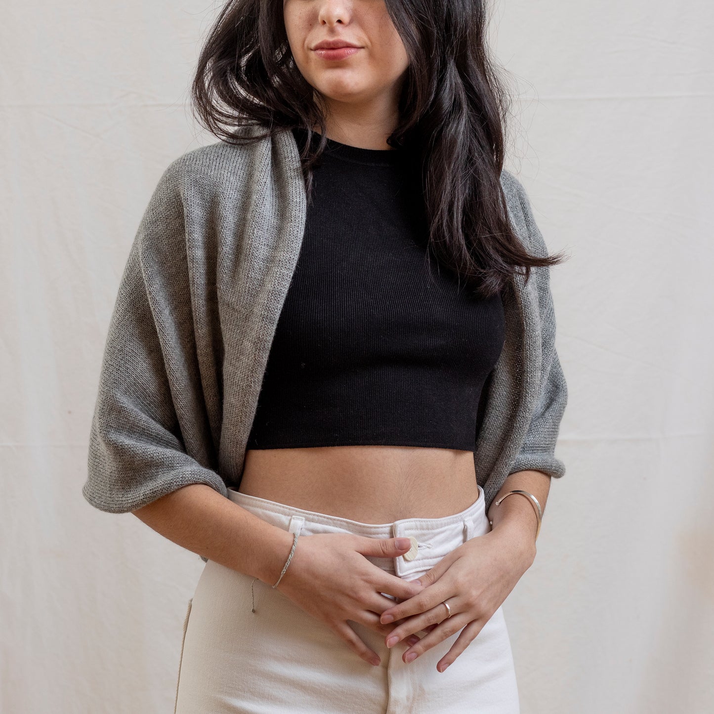 Woman wearing stone coloured luxury infinity scarf as a shrug with leather strap detail.