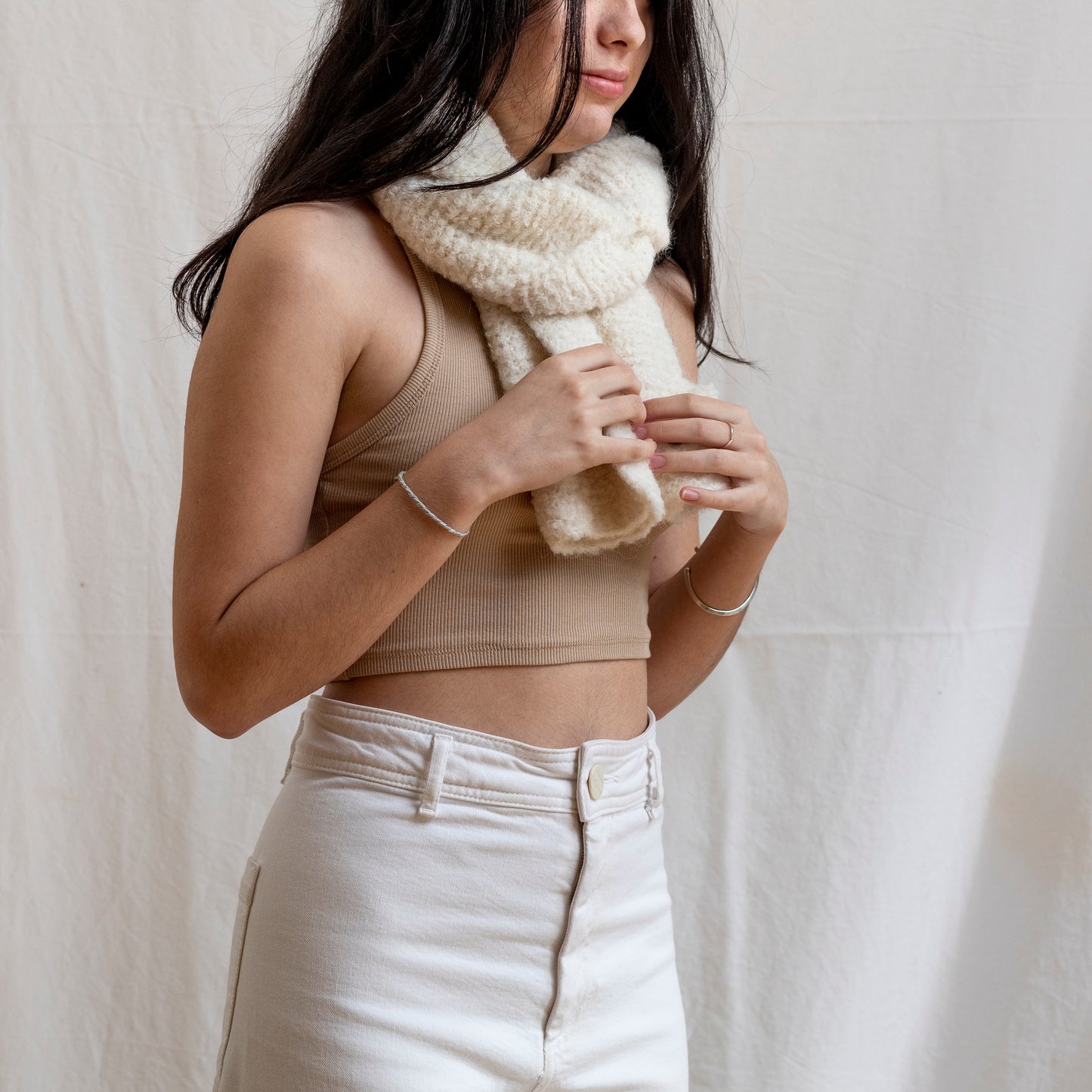 Woman wearing a luxury, boucle and natural coloured lightweight scarf.