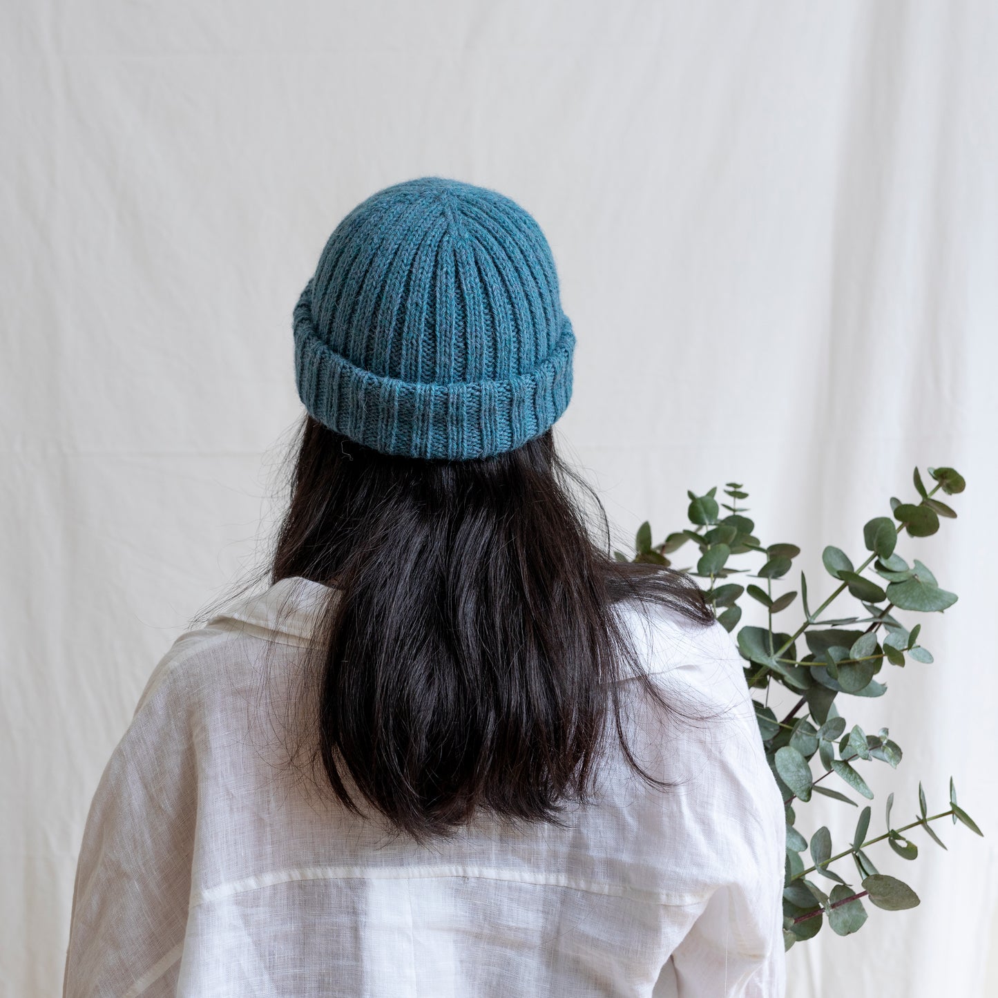Woman wearing light blue coloured soft beanie with rib detail made from alpaca wool.