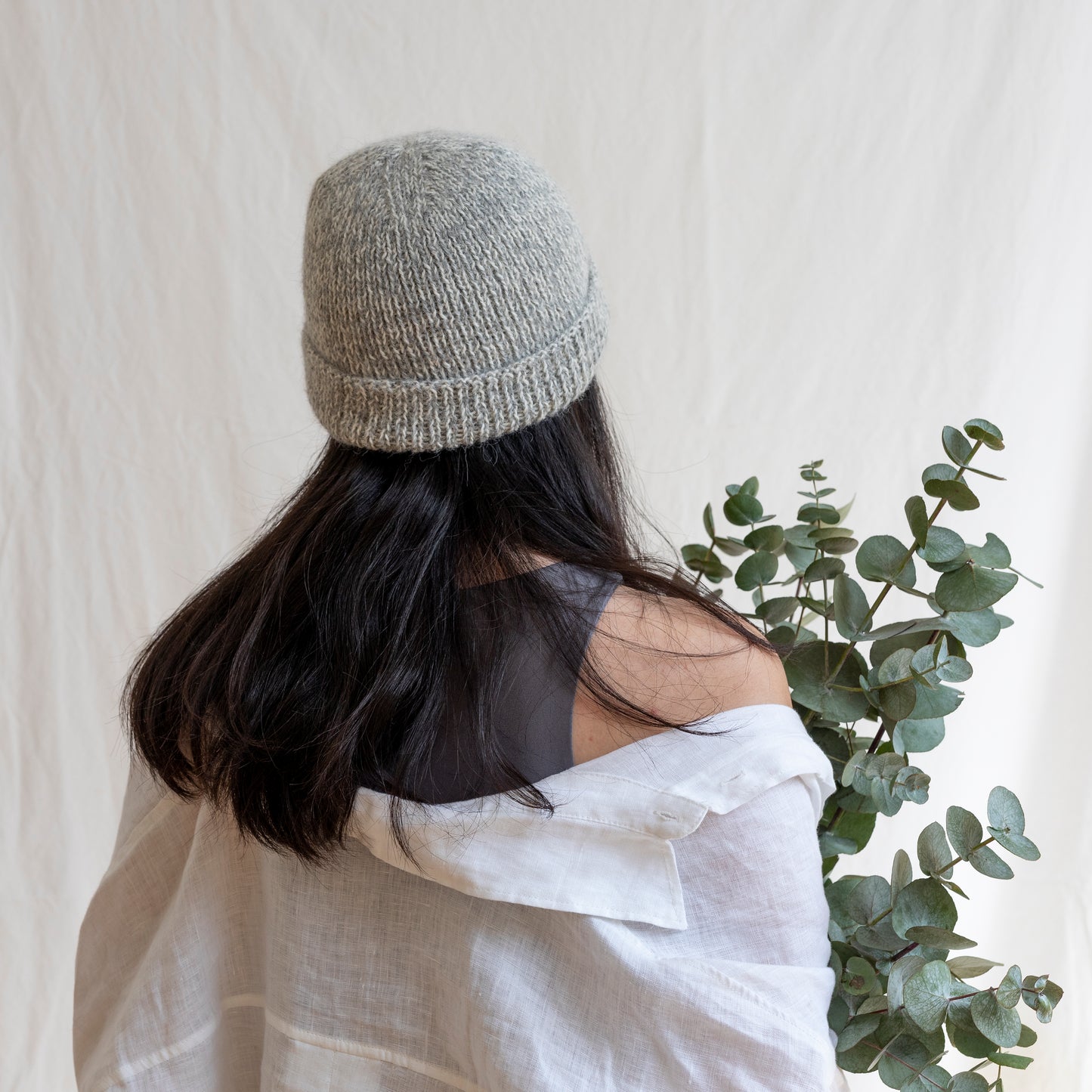 Woman wearing soft and luxurious alpaca knit fisherman's beanie in color stone.