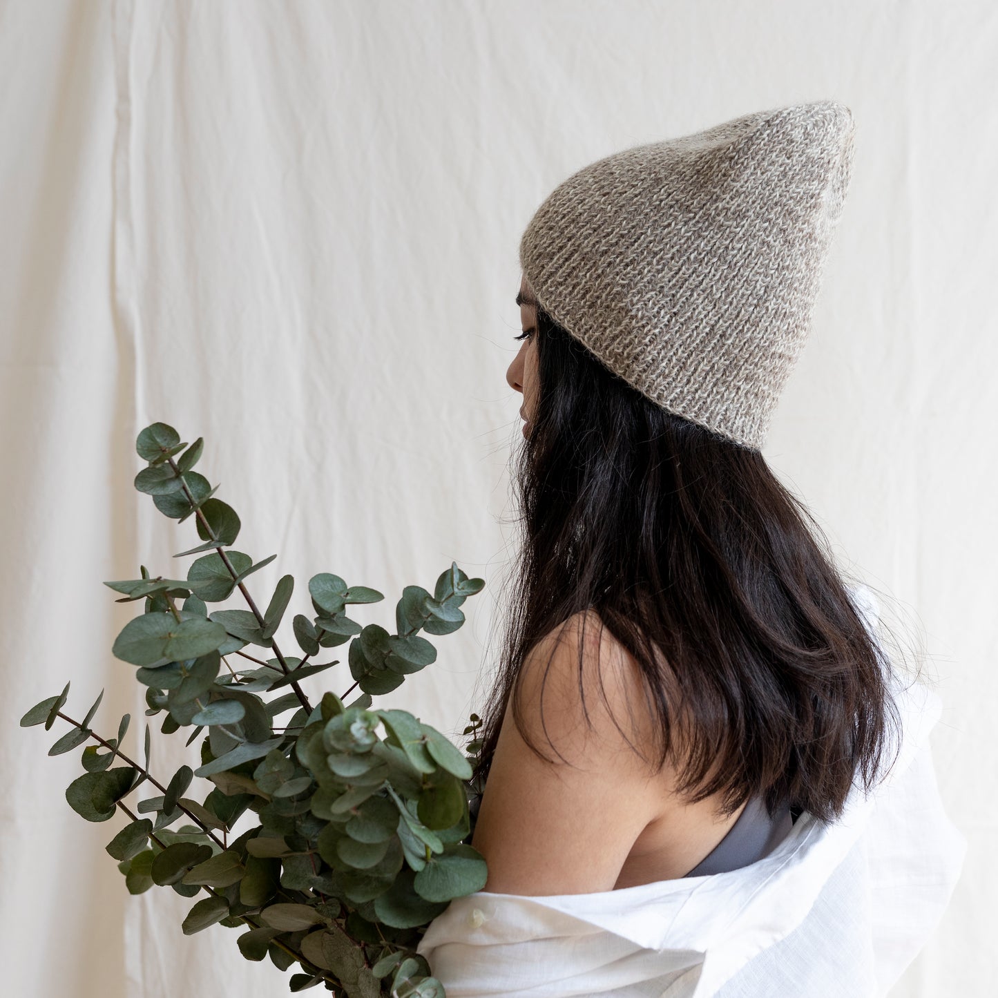 Woman wearing soft and luxurious alpaca knit fisherman's beanie in color beige.