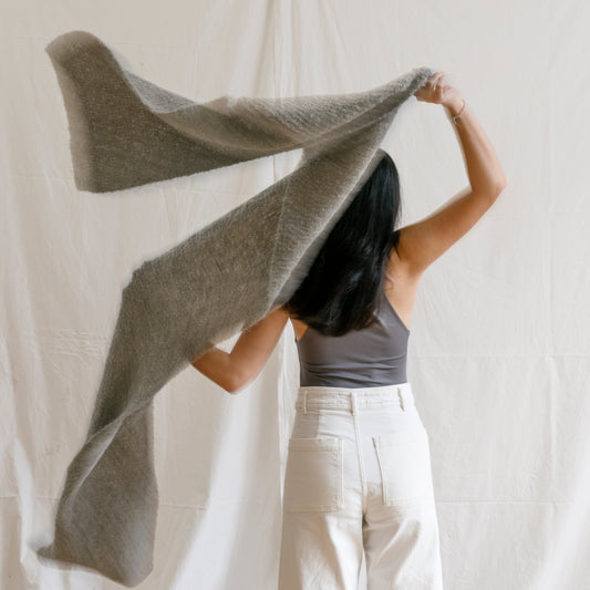 Woman with luxury hand-knitted alpaca wool grey scarf