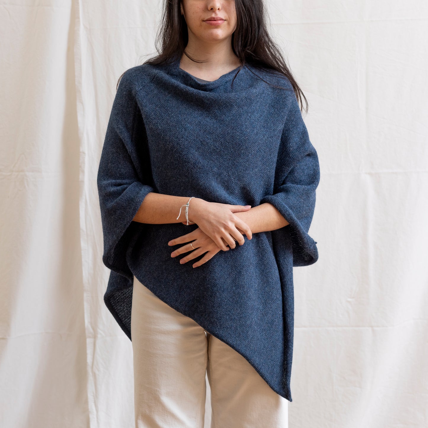 Woman wearing dark blue alpaca wool lightweight poncho.