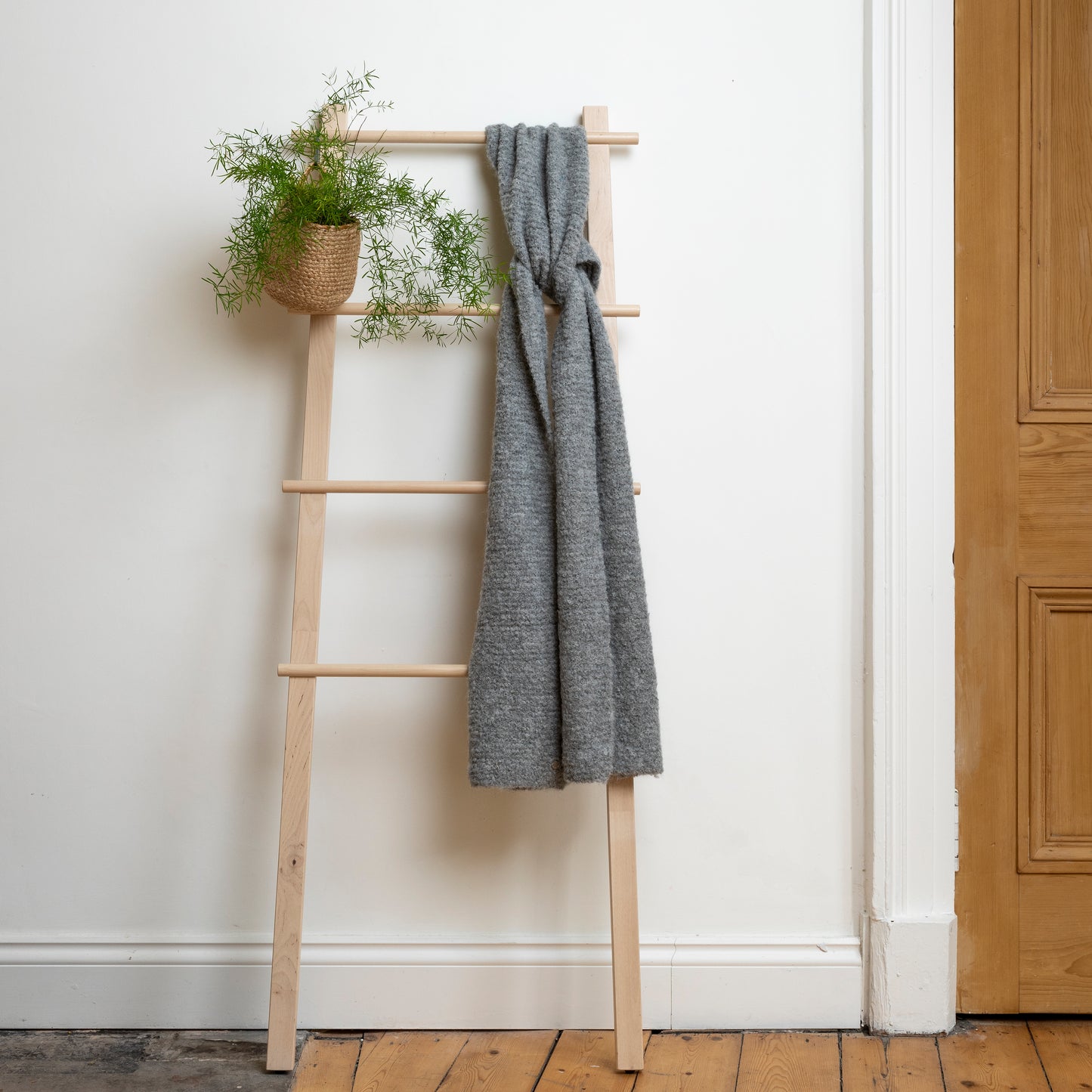 Beautiful, one of a kind grey hand-knitted scarf handknitted in luxury alpac displayed on wooden ladder