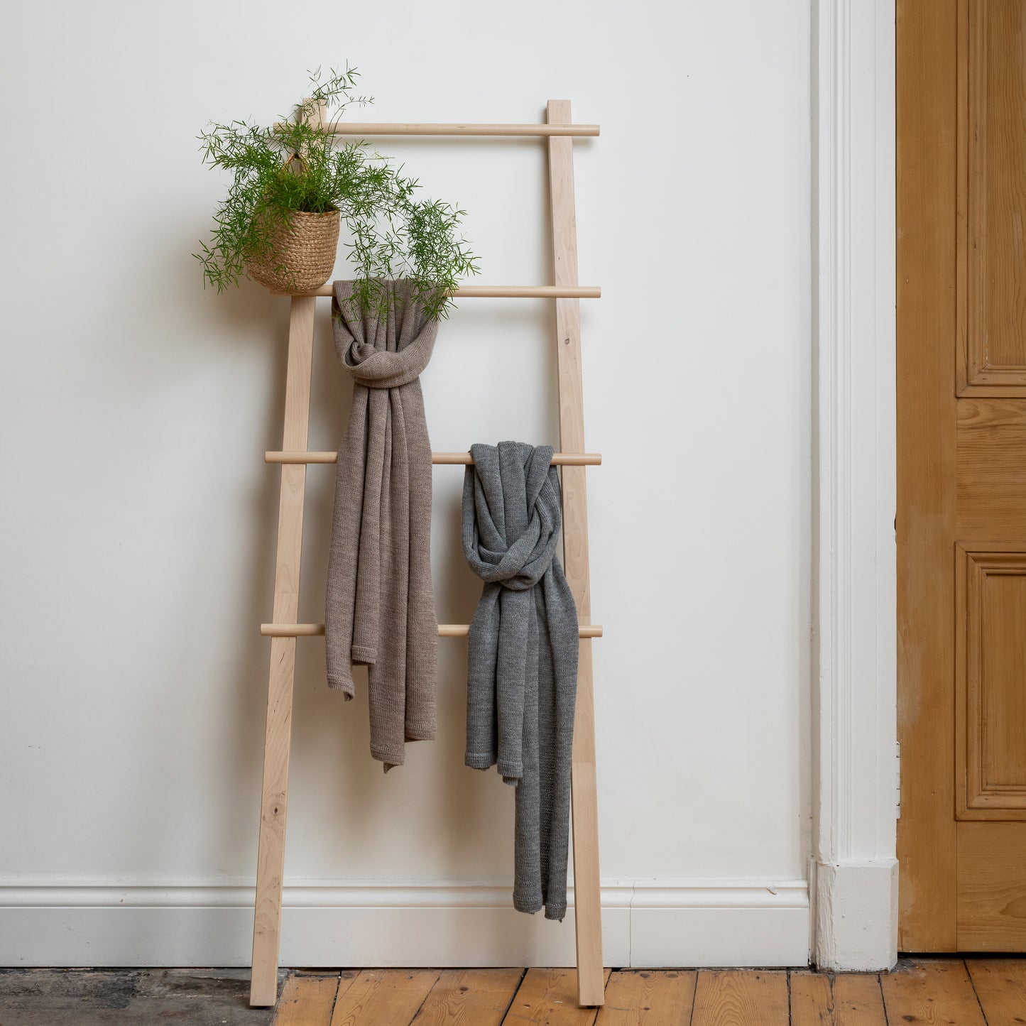 Unique, soft and beautiful scarves hanging loosely from wooden steps.