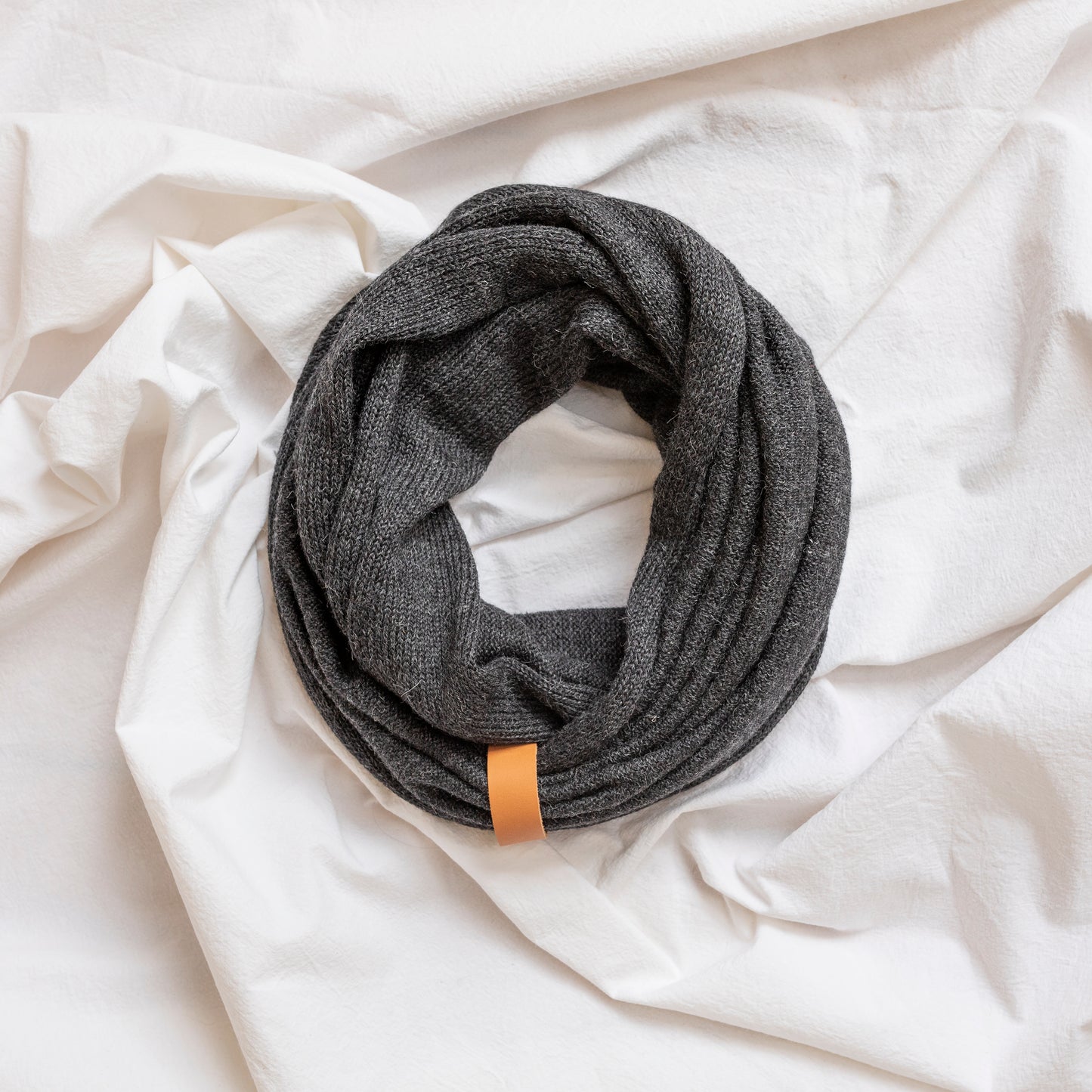 Charcoal coloured luxury infinity scarf with leather strap detail.