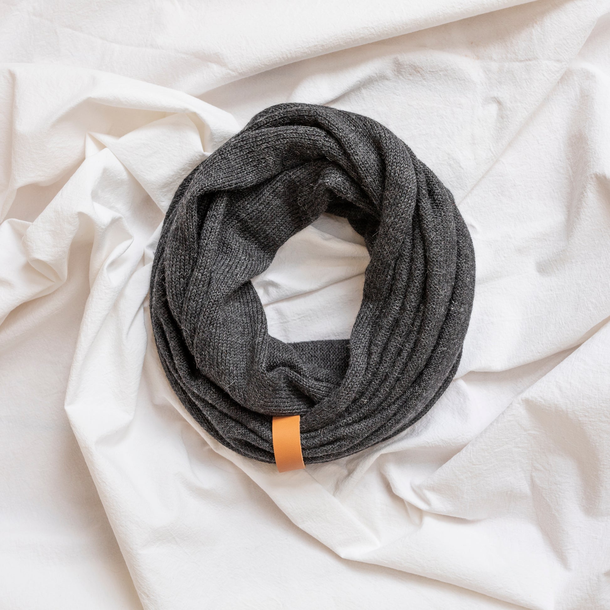 Charcoal coloured luxury infinity scarf with leather strap detail.