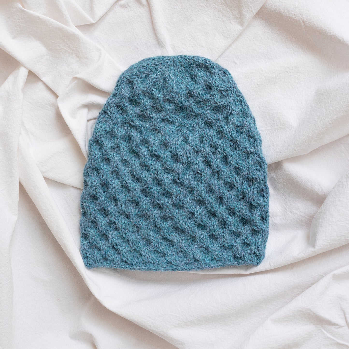 Textured hand-knitted sky blue coloured beanie hat.