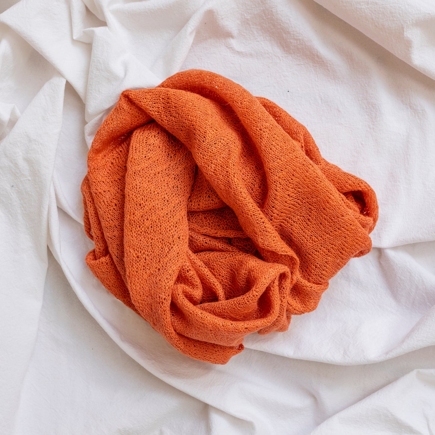 Orange coloured lightweight and delicately woven scarf. Hand-made by artisans.