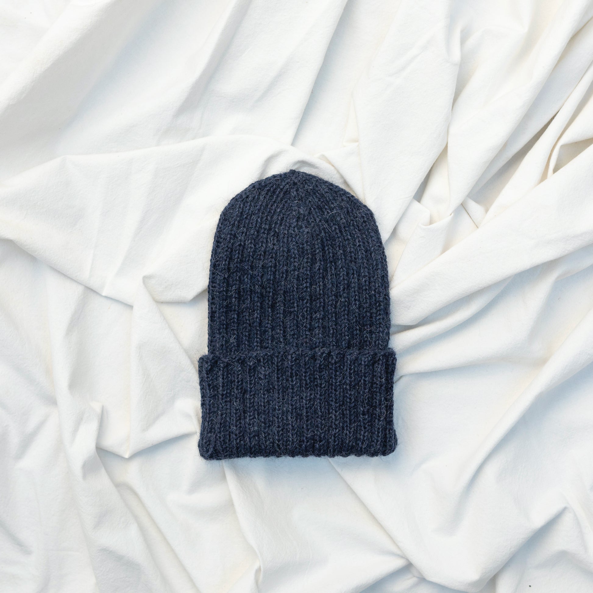Dark blue coloured soft beanie with rib detail hand knitted with alpaca wool 