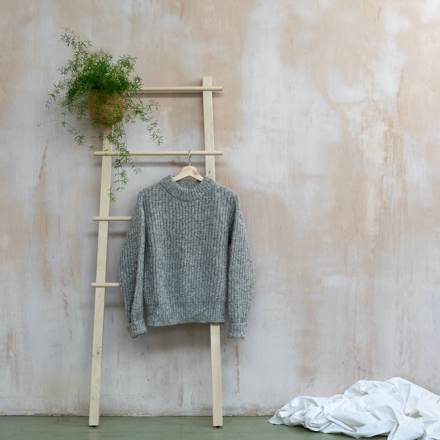 Round neck chunky sweater, light grey, displayed on a ladder 