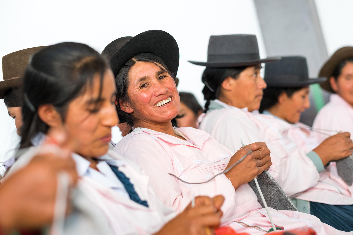 Peruvian woman smiling as she knits
