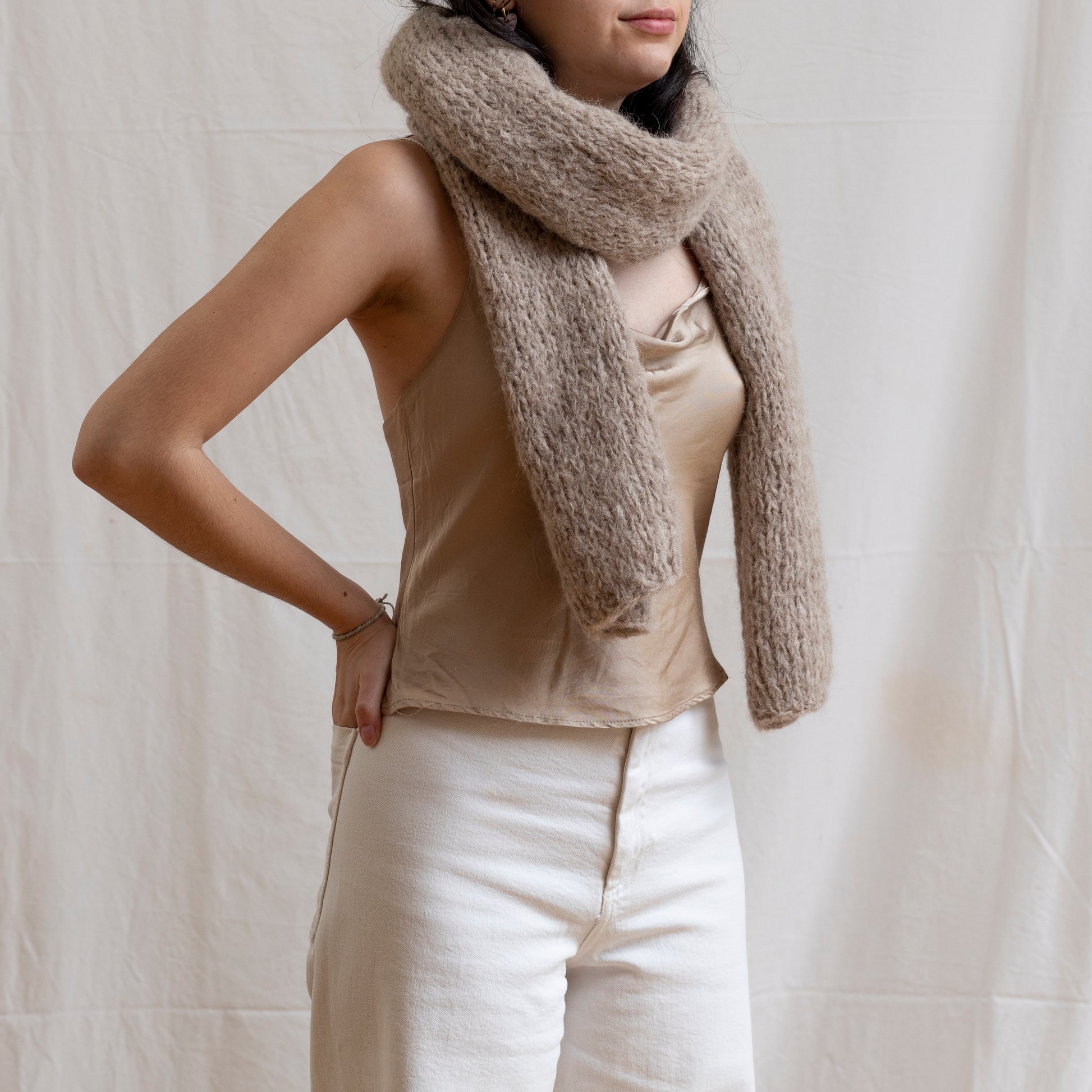 Woman wearing chunky super-soft knitted scarf in colour oatmeal. 