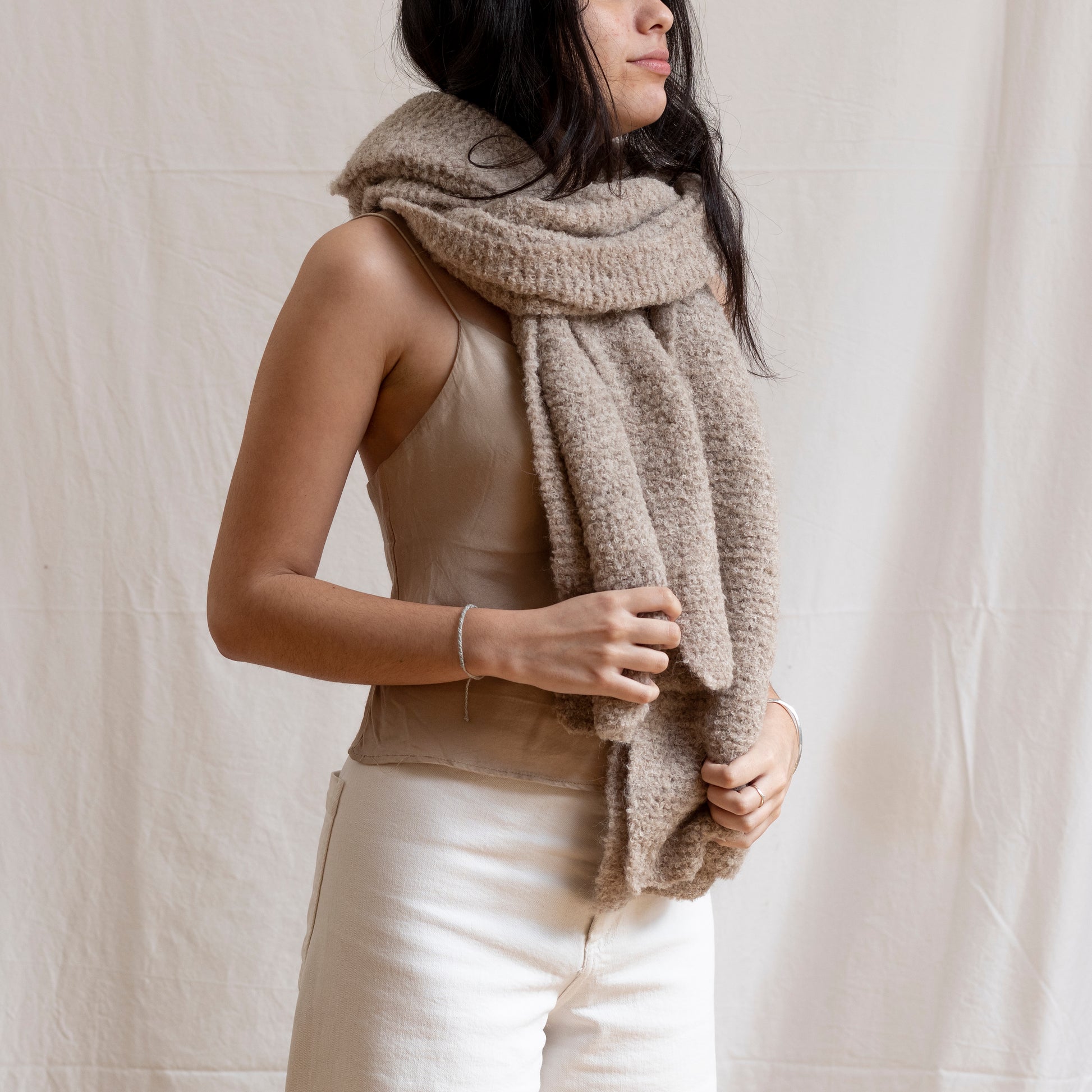 Woman with hand-knitted, cosy and artisan luxury  alpaca wool chunky beige scarf