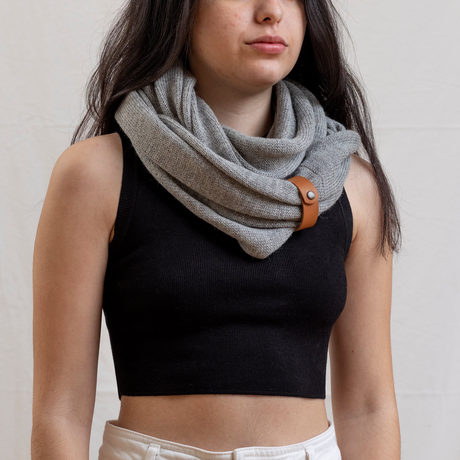 Woman wearing stone coloured luxury infinity scarf with leather strap detail.