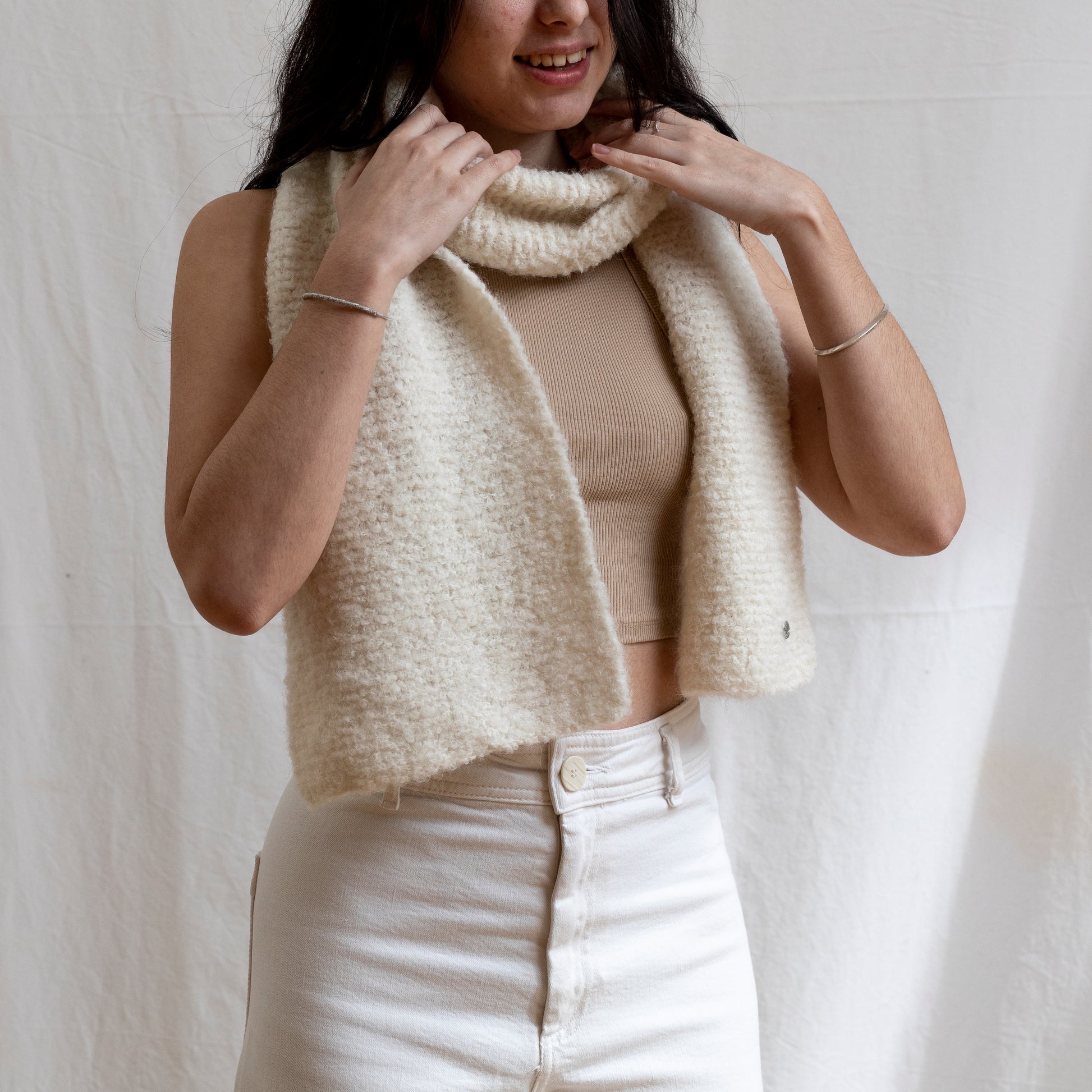 Woman wearing a luxury, boucle and natural coloured lightweight scarf. 