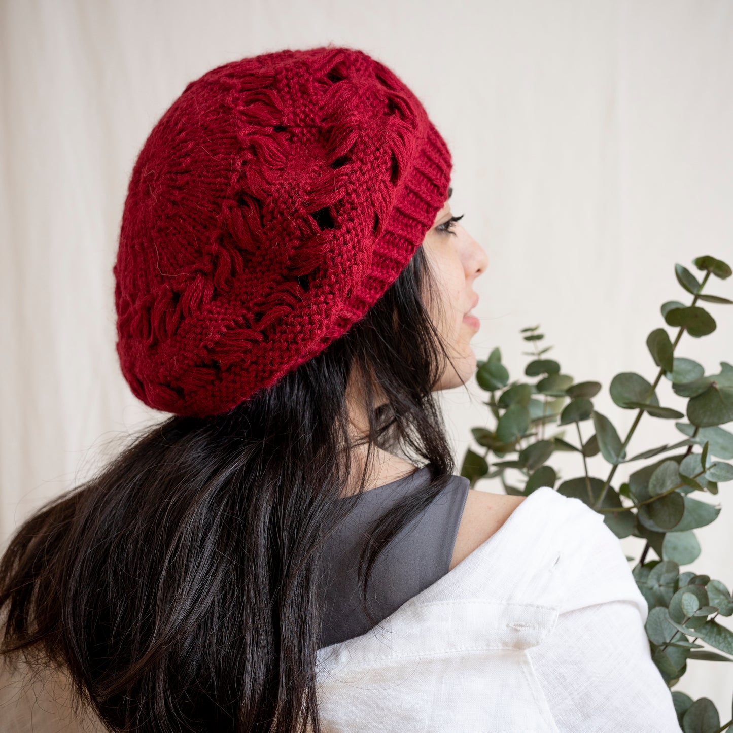 Woman wearing burgundy hand-knitted alpaca wool beret. Gorgeous, flattering and soft. 