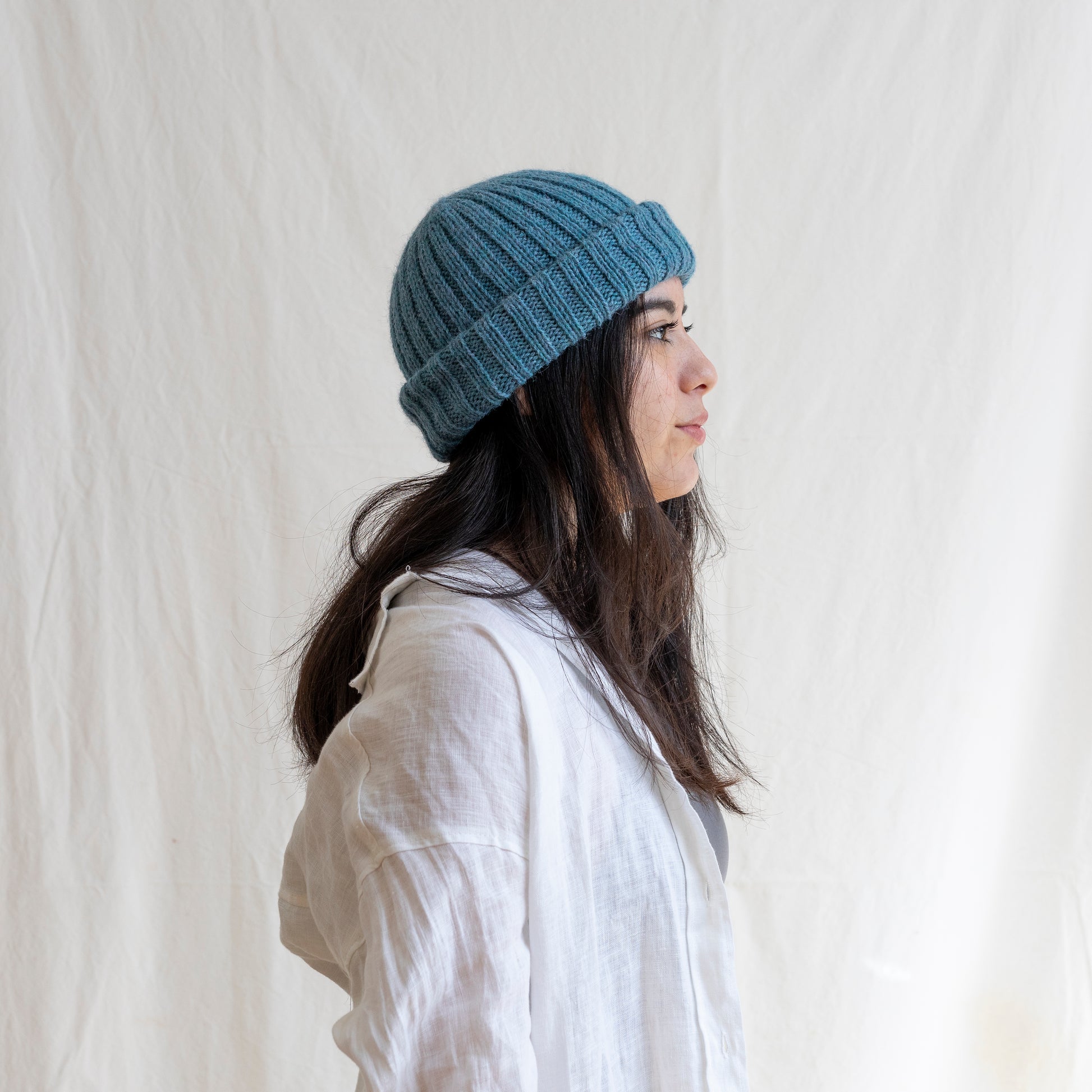 Woman wearing light blue coloured soft beanie with rib detail made from alpaca wool.