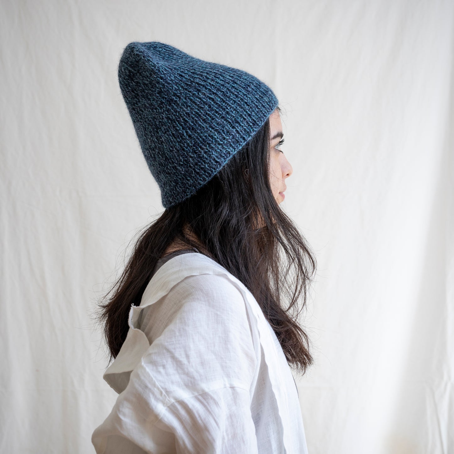 Woman wearing soft and luxurious alpaca knit fisherman's beanie in color blue. 