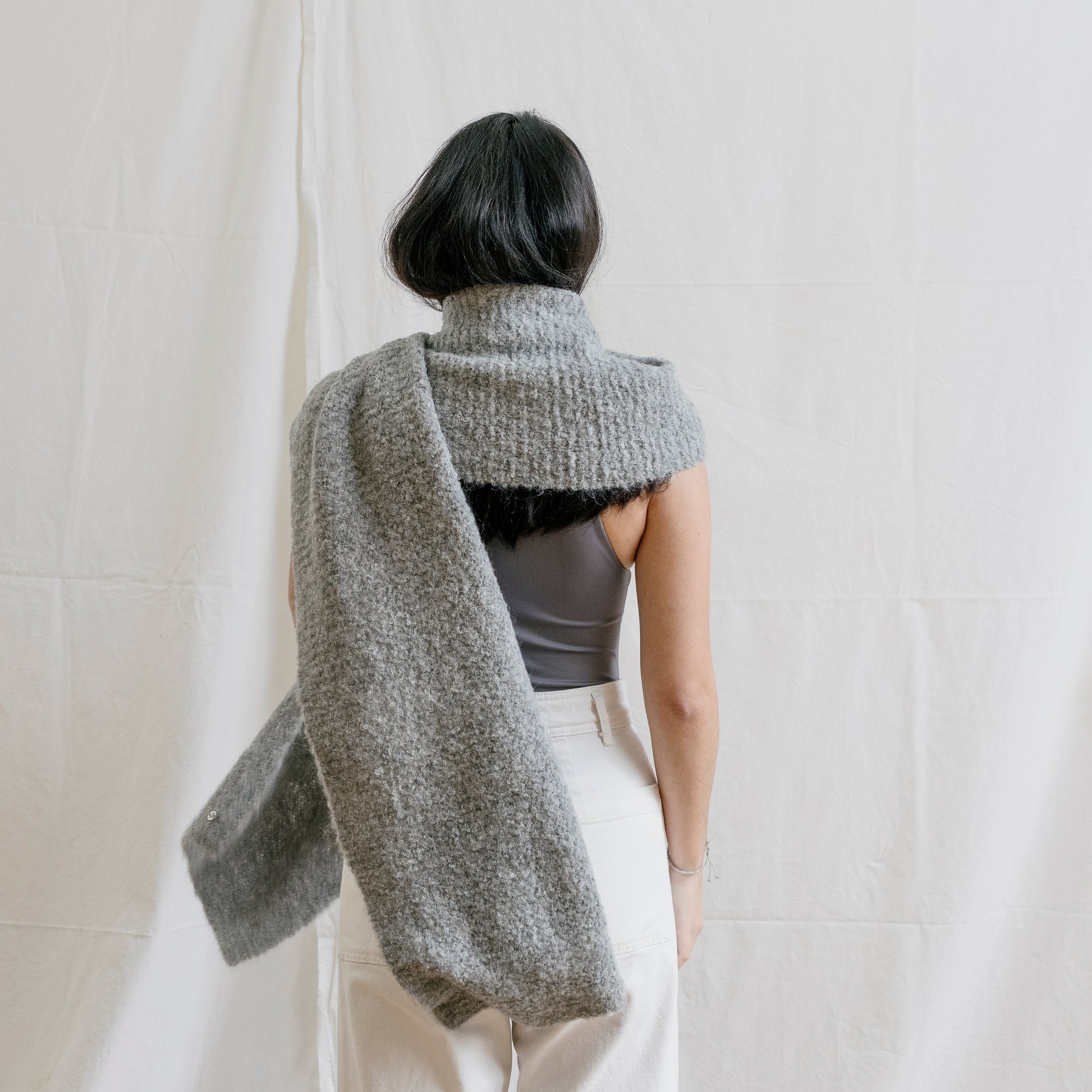 Woman with hand-knitted, cosy and artisan alpaca wool chunky grey scarf