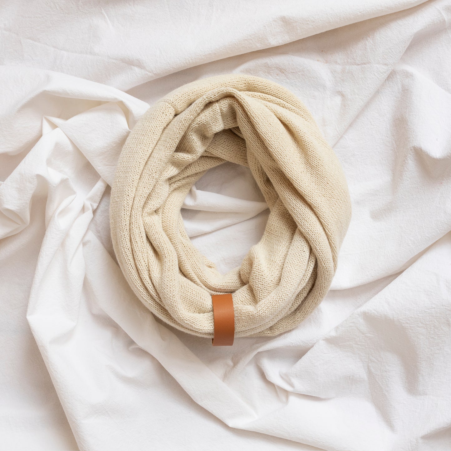 Natural coloured luxury infinity scarf with leather strap detail.