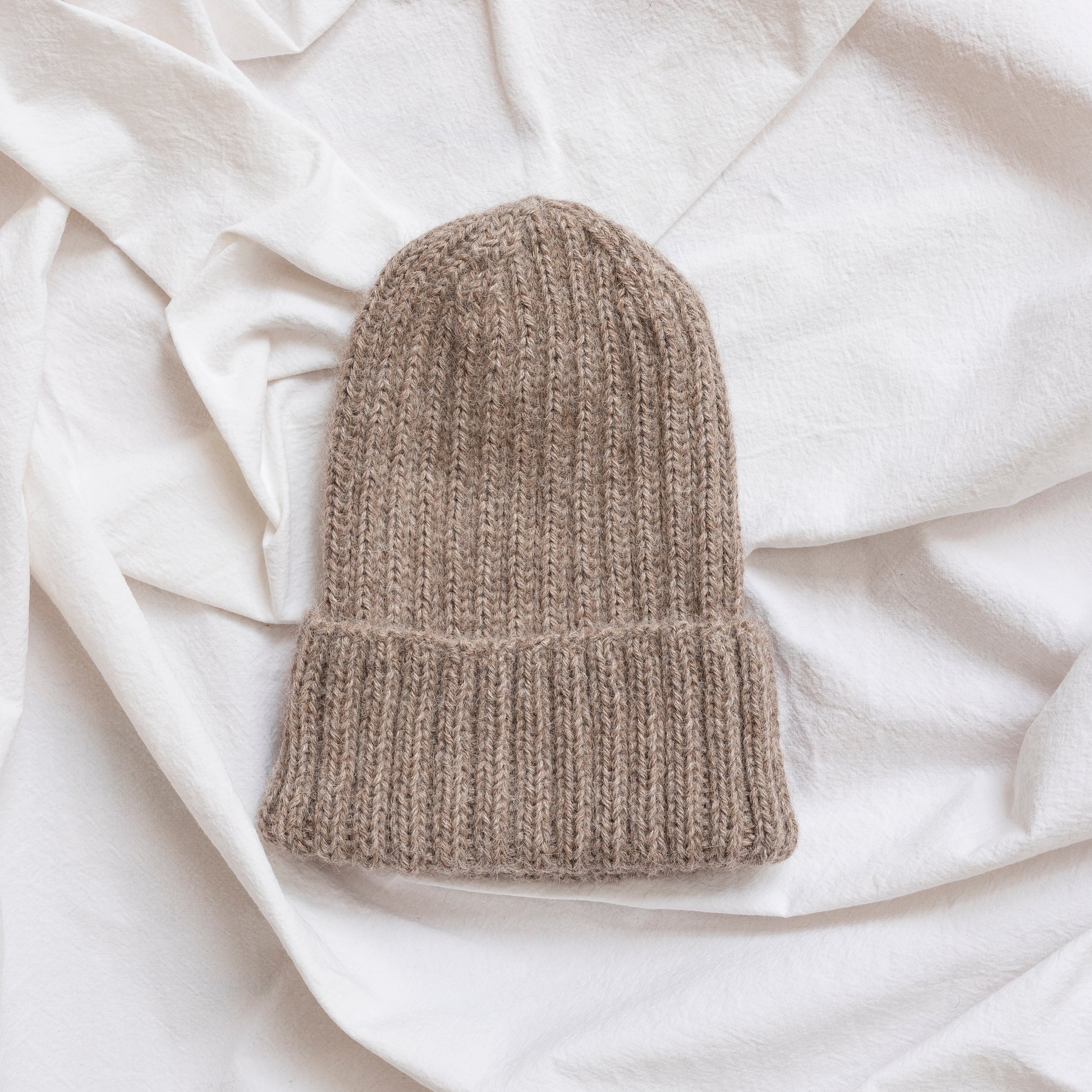Oatmeal coloured soft beanie with rib detail made from alpaca wool.