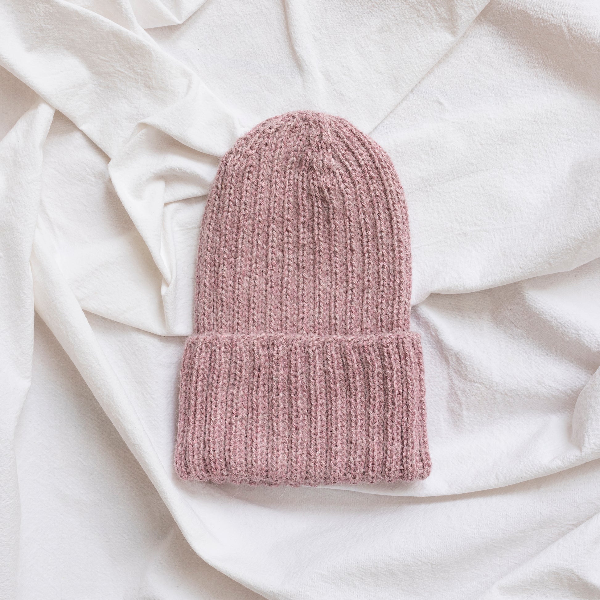 Rose pink coloured soft beanie with rib detail made from alpaca wool.