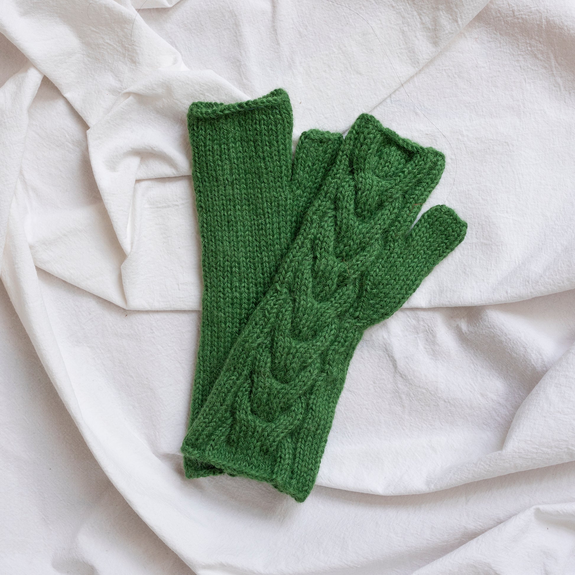 Green coloured, super-soft and silky hand-knitted alpaca wool mittens.